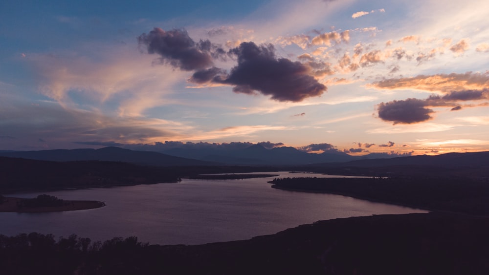 plan d’eau sous ciel nuageux pendant la journée