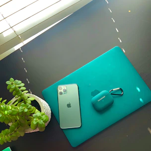 A neatly arranged workspace featuring light apricot and cyan tones with phone case materials.