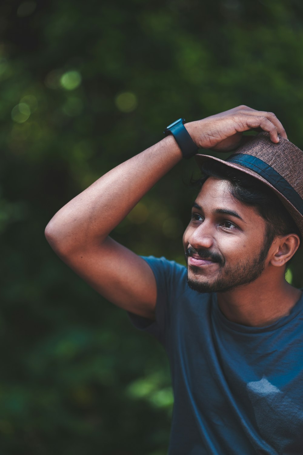 Hombre con camiseta azul de cuello redondo con sombrero Fedora negro y gris