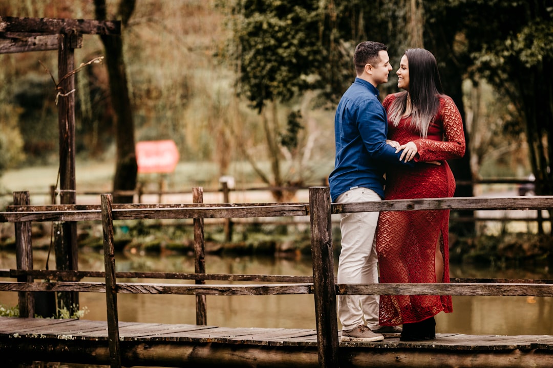 man in blue jacket standing beside woman in red dress