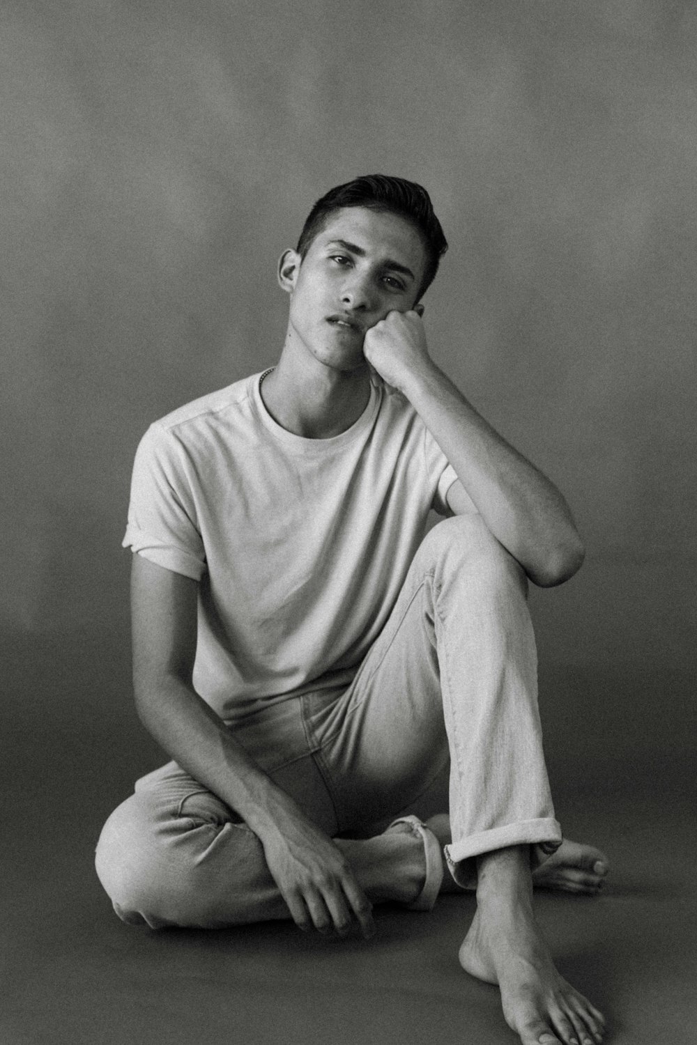 man in white crew neck t-shirt sitting on chair