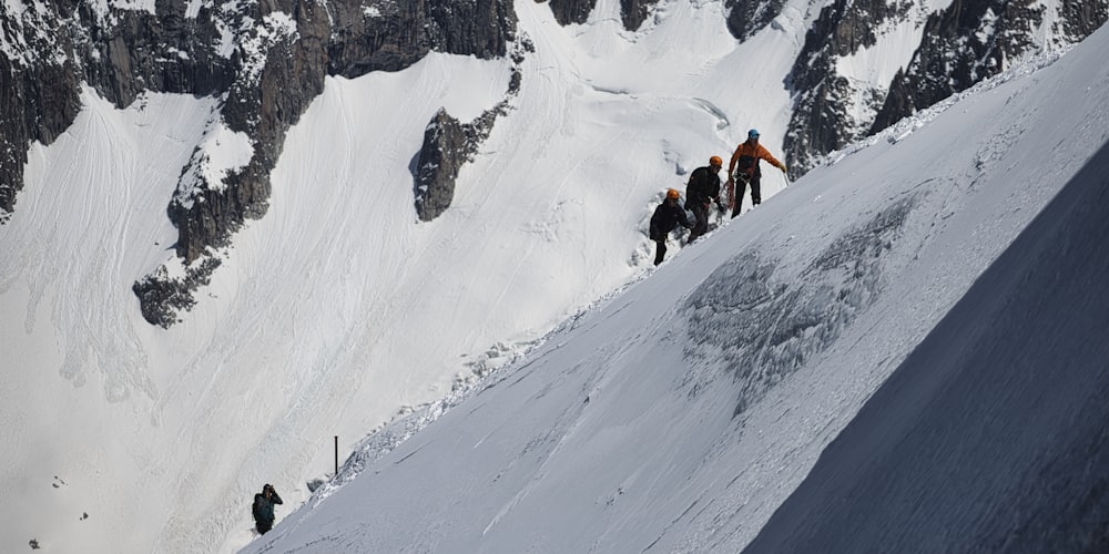 people hiking on snow covered mountain during daytime