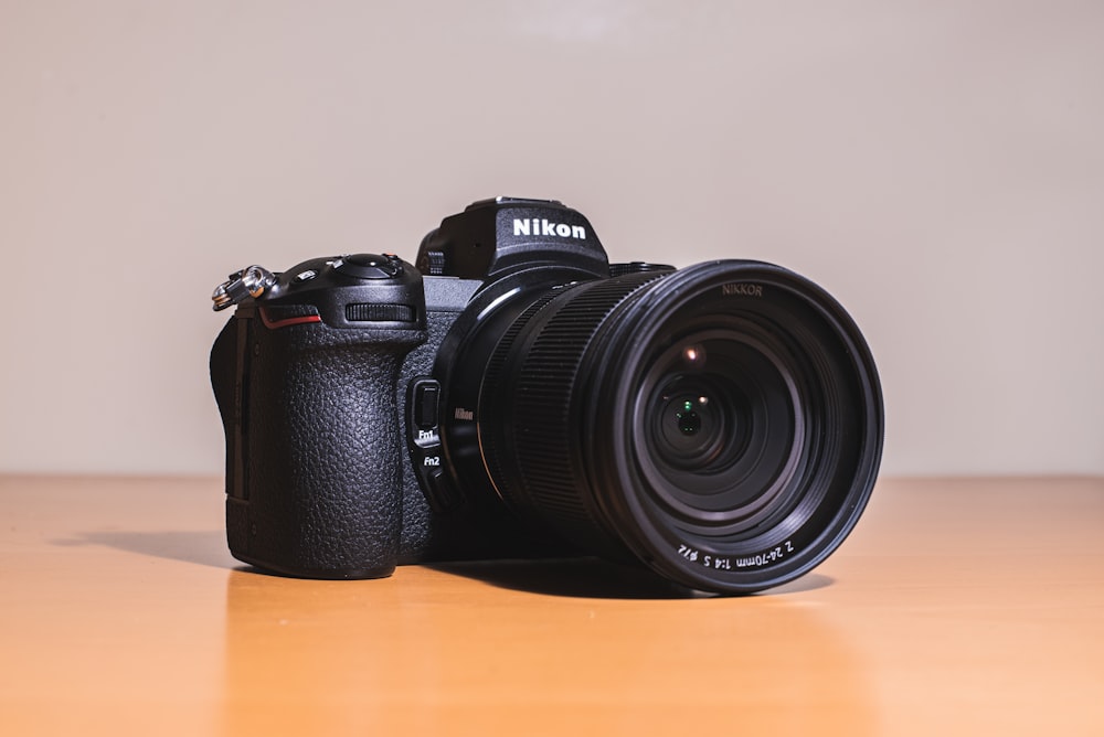 black nikon dslr camera on brown wooden table