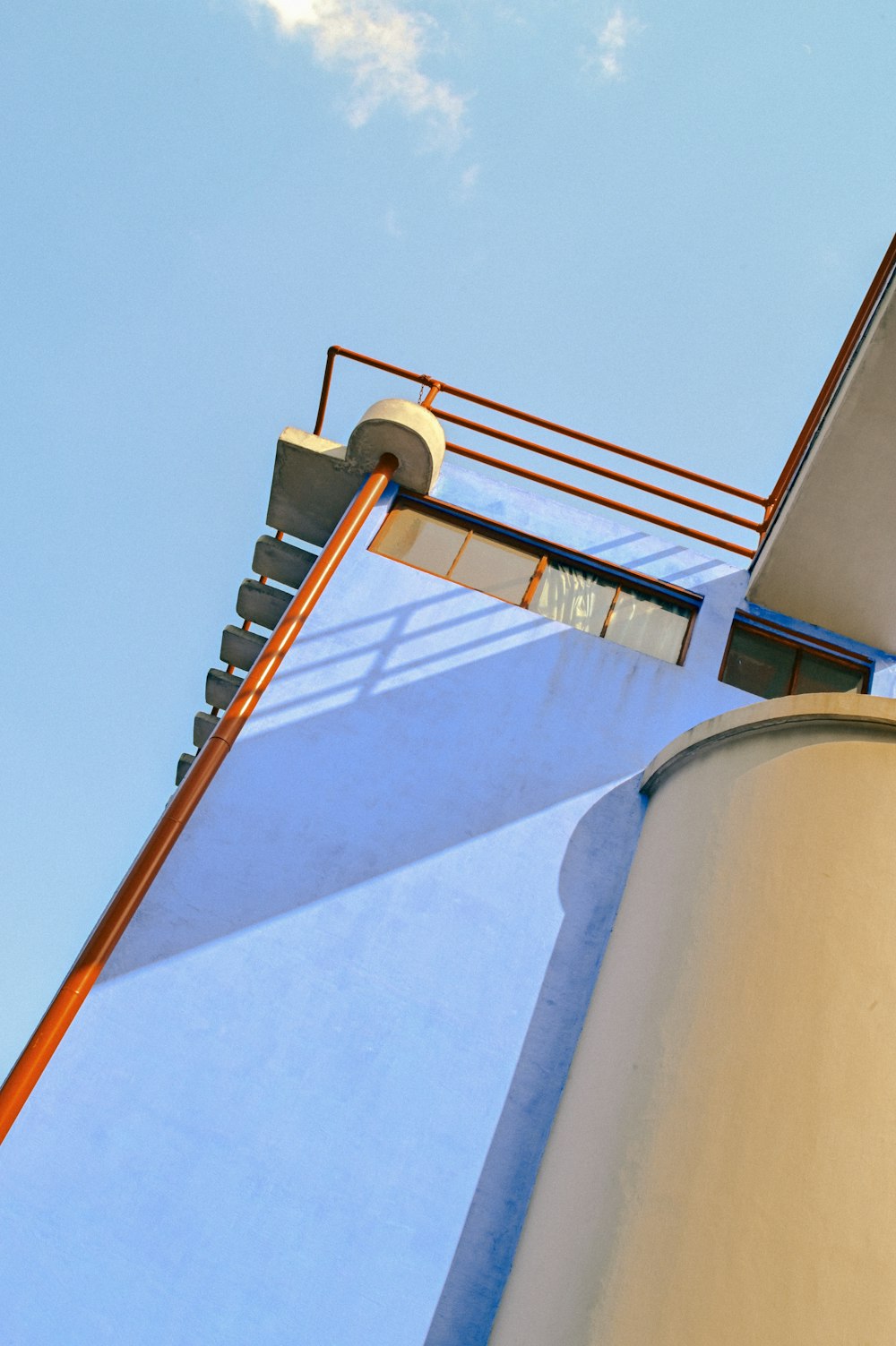 brown metal ladder on white concrete wall