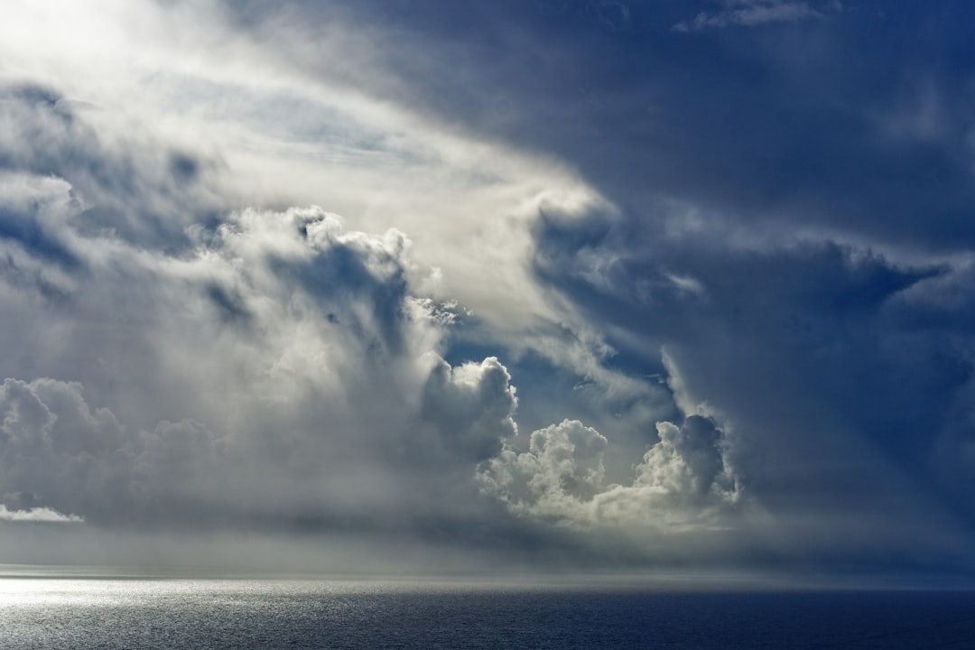 blue sea under white clouds and blue sky during daytime