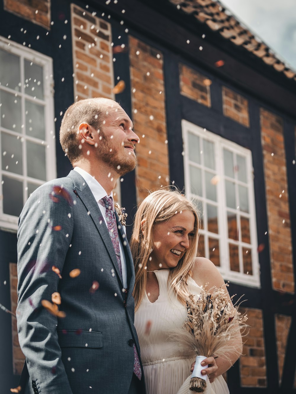 man in blue suit jacket standing beside woman in white dress