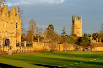 Historic stone facade of Marmion Lodge bathed in warm afternoon light, with Tamworth Castle visible in the background.