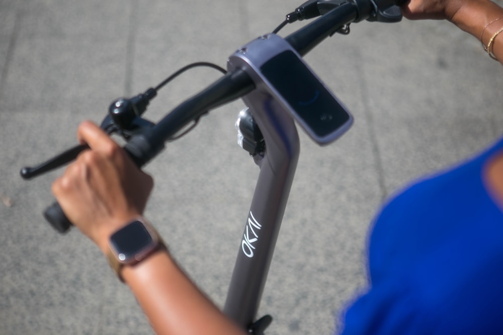 person in blue shirt riding black bicycle