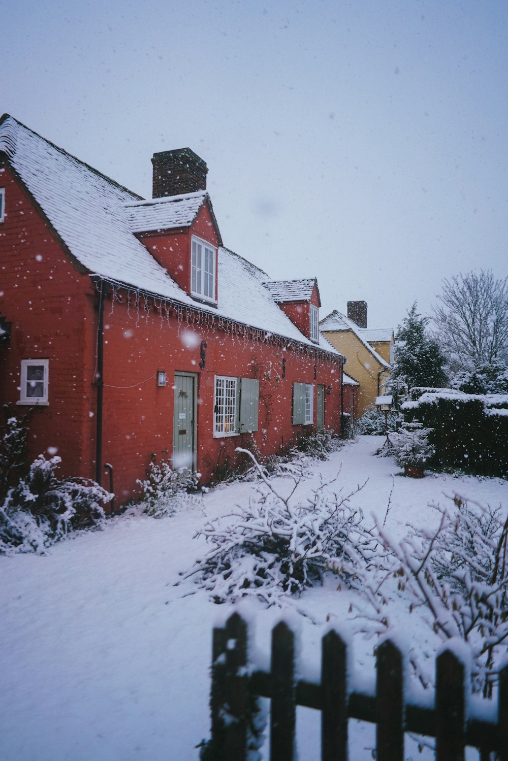 red and white concrete house surrounded by snow covered ground