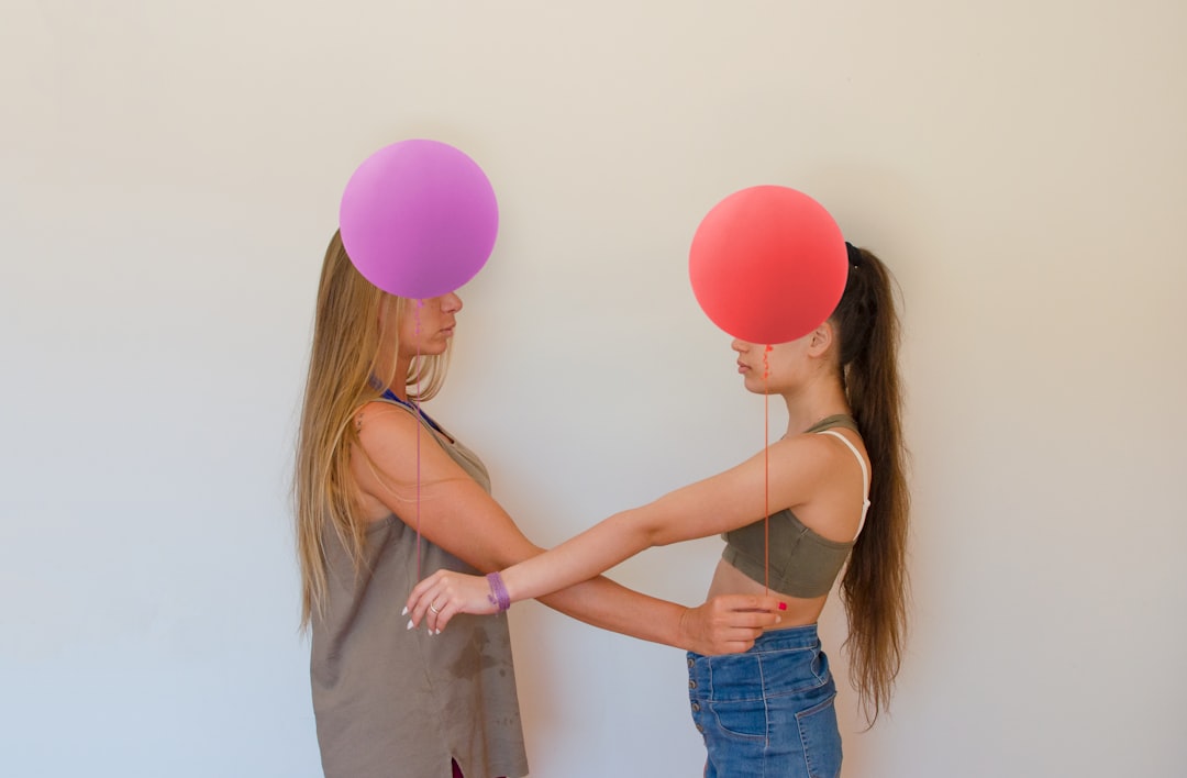 woman in blue denim shorts holding pink balloons