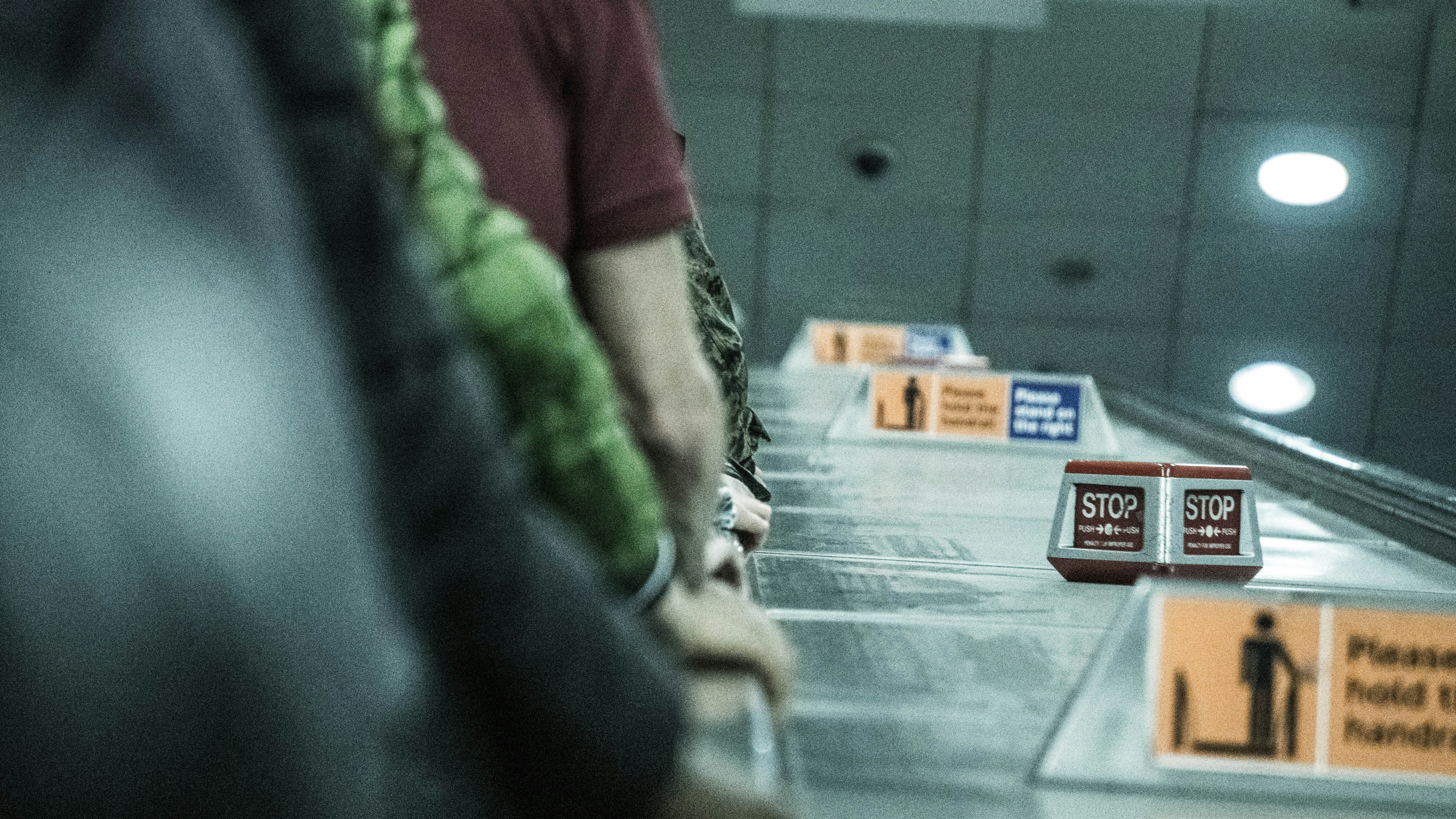 person in red shirt standing near glass wall, 