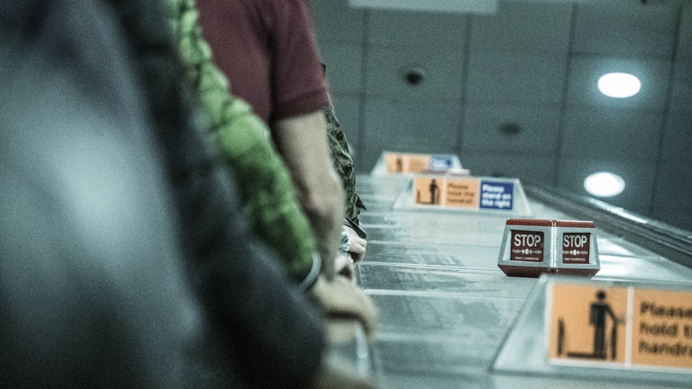 person in red shirt standing near glass wall