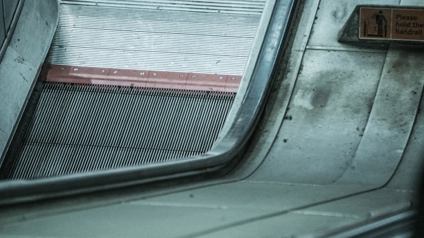 Close-up of a sleek escalator handrail with the Kalkar Enterprise logo visible.