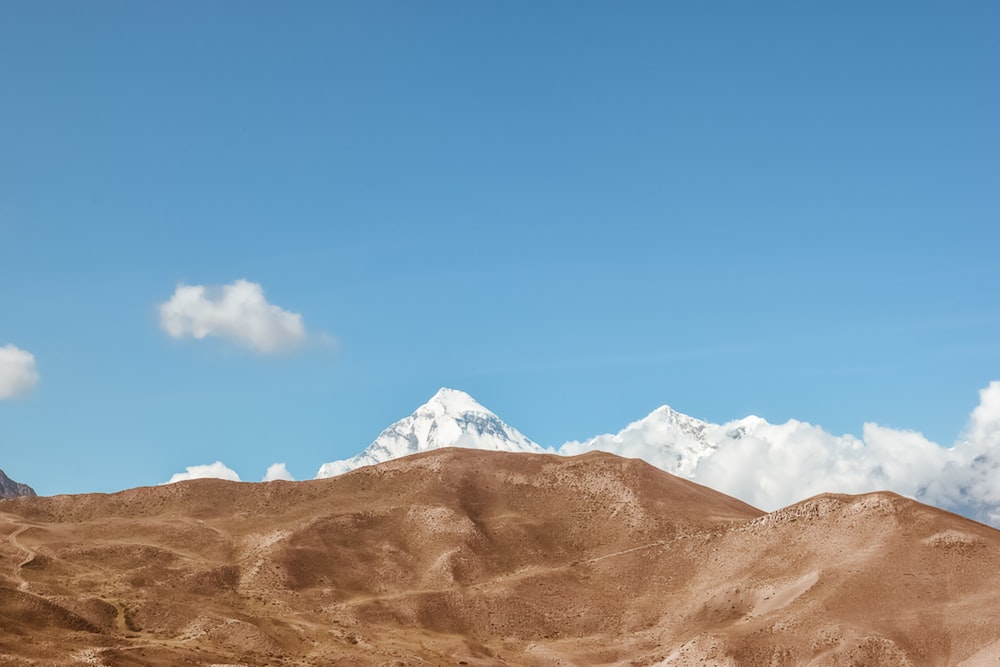 montagnes brunes et blanches sous le ciel bleu pendant la journée