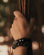 person wearing black and silver bracelet