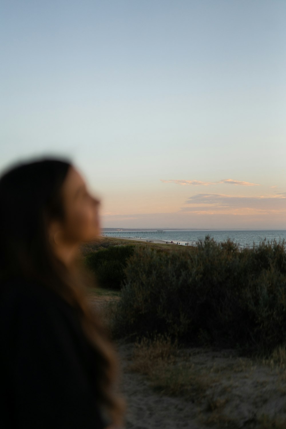 woman in black jacket standing on green grass field during daytime