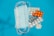 A collection of medical items, including several surgical masks and various blister packs of pills, are placed on a blue background.