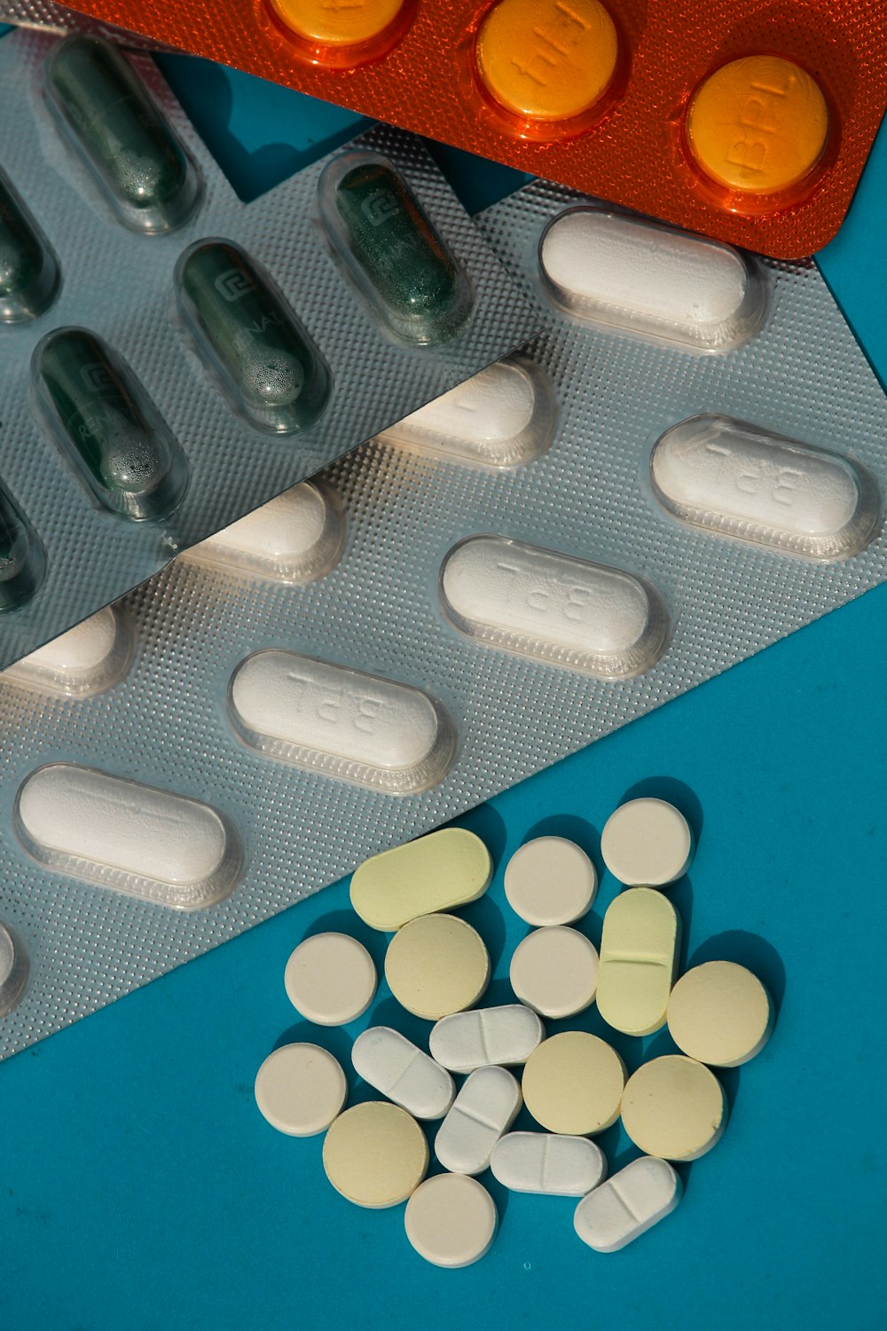 píldora de medicación ovalada blanca sobre superficie azul