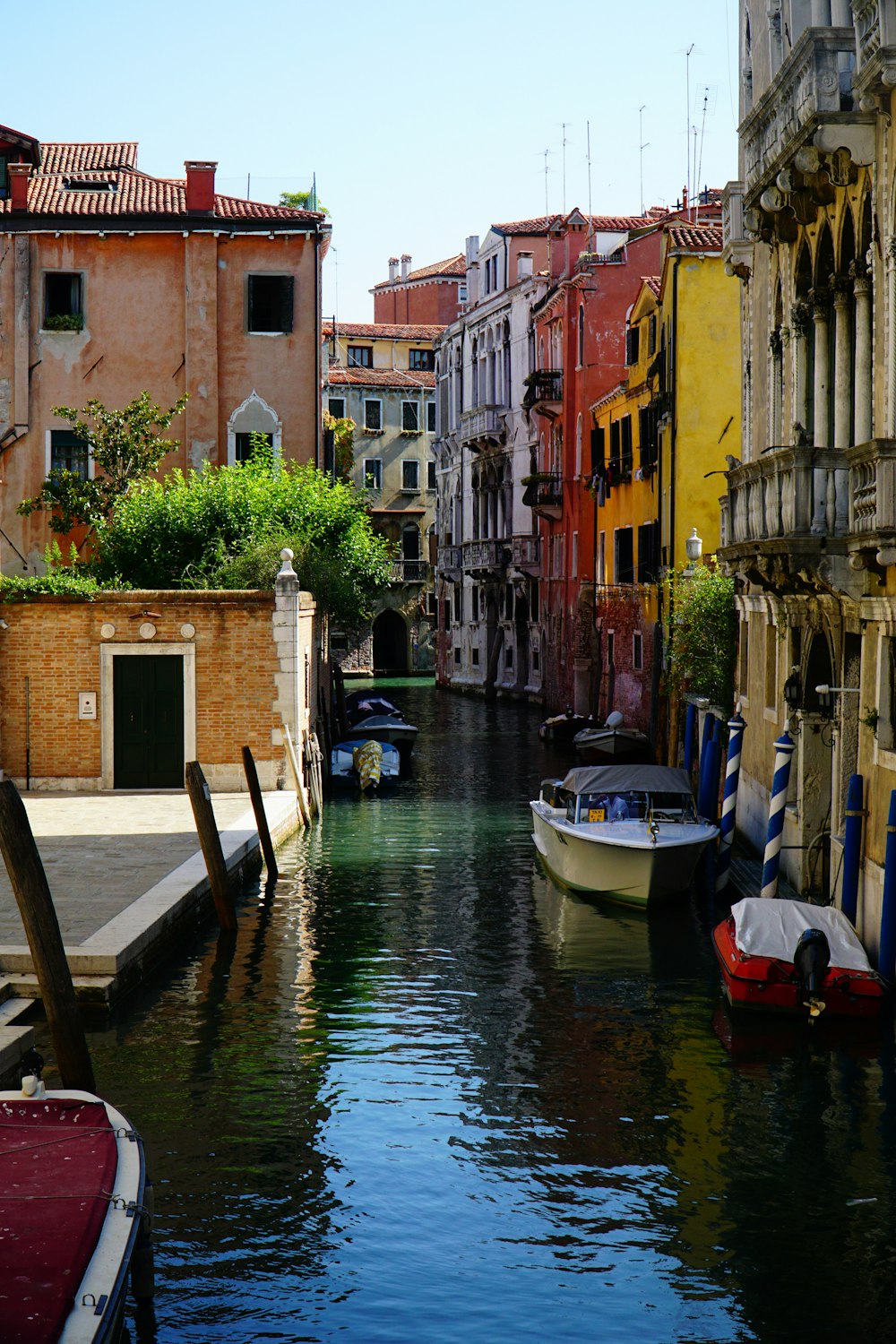 blue and white boat on river between brown concrete buildings during daytime