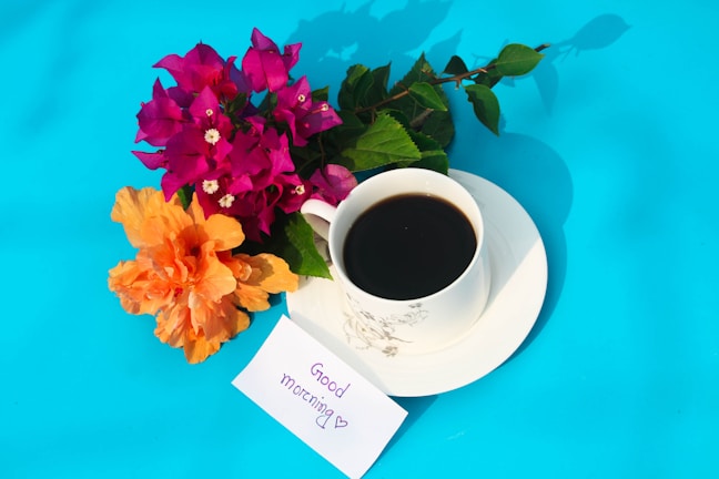A handwritten note with loving words beside a cup of coffee on a wooden table.
