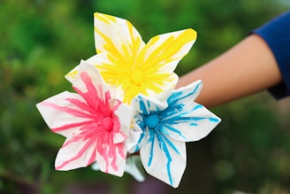 A colorful preschool art project with hand-painted paper flowers and smiling children working together