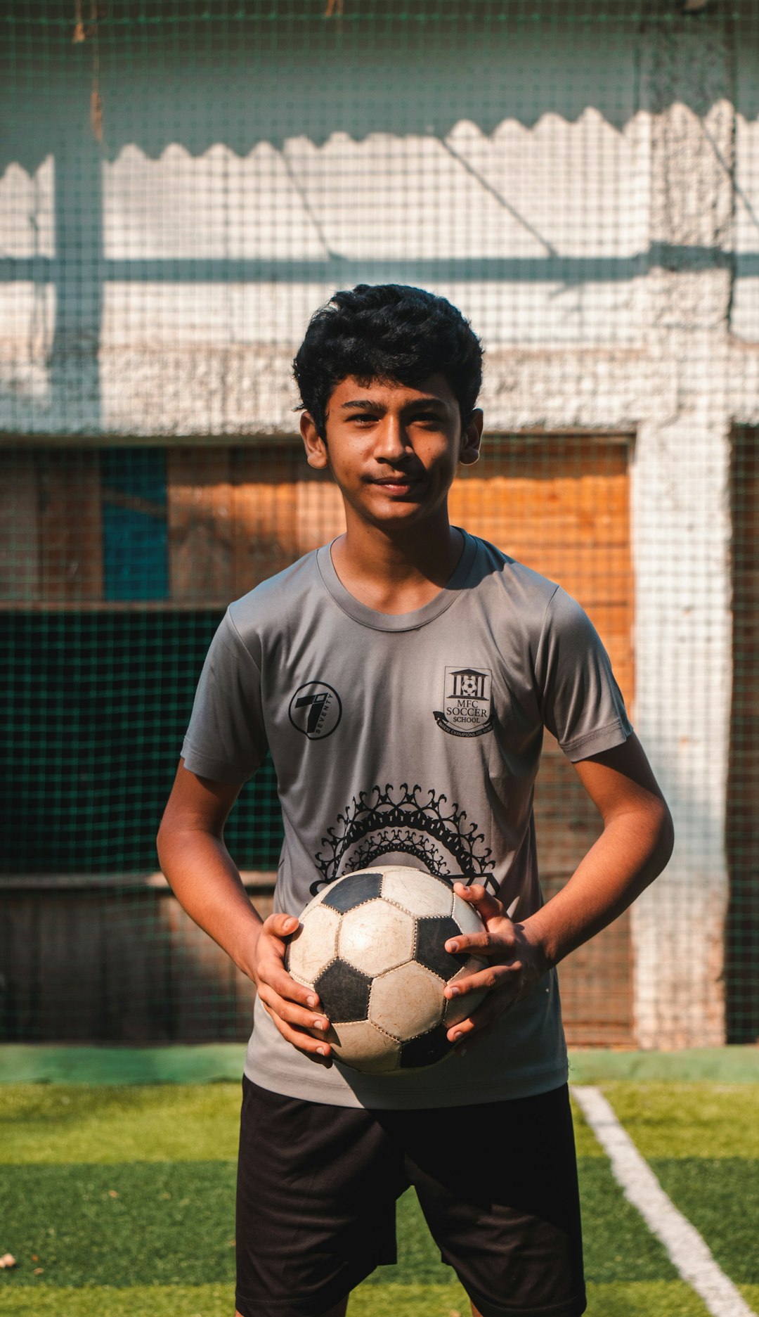 man in gray crew neck t-shirt holding soccer ball