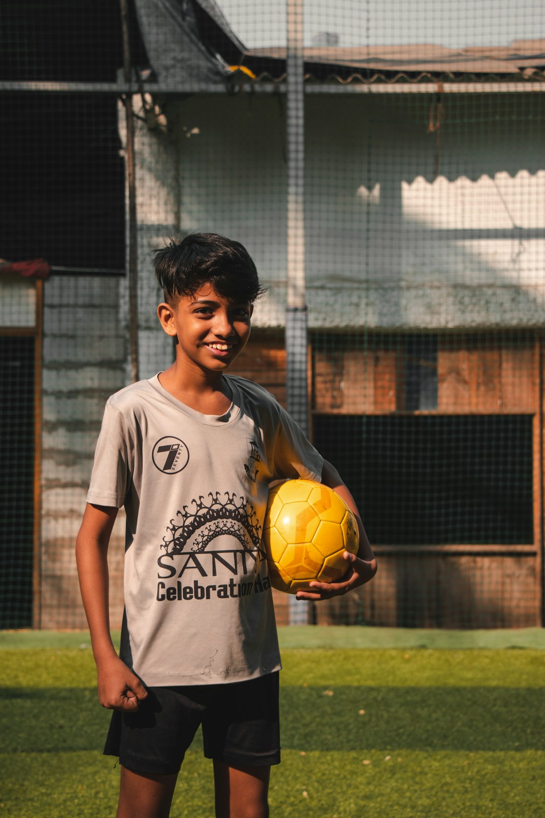 man in white crew neck t-shirt holding yellow soccer ball