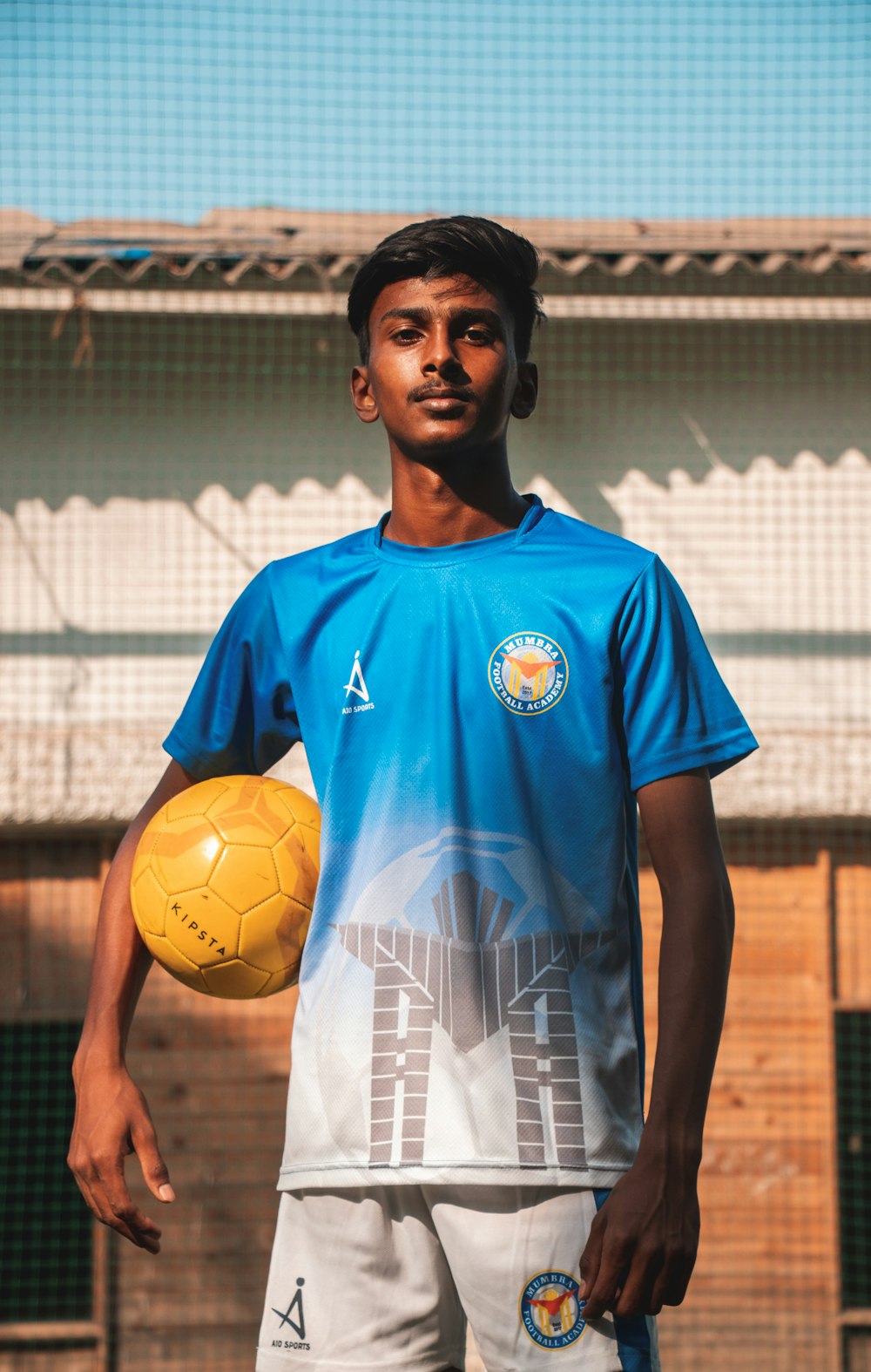 Foto Hombre con camiseta de fútbol nike azul y blanca sosteniendo un balón  de fútbol amarillo – Imagen Esfera gratis en Unsplash