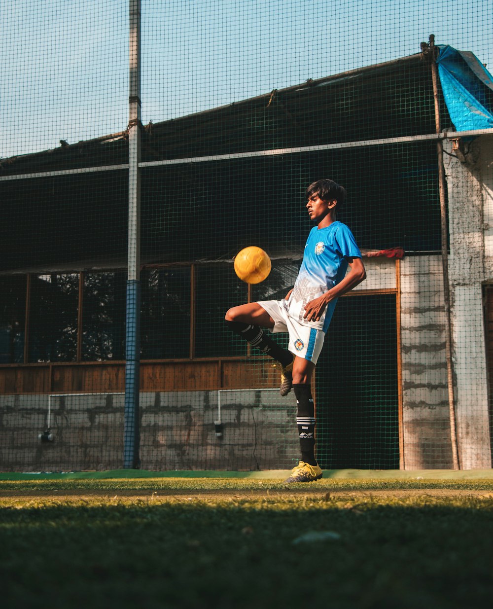 man in blue shirt and black shorts playing basketball during daytime