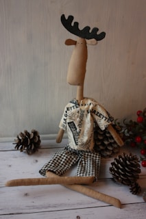 An artistic shot of a moosi plush reindeer against a rustic wooden backdrop, highlighting its soft textures.