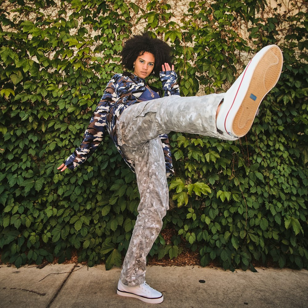 boy in black and white jacket and gray pants wearing brown and white nike sneakers jumping