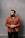 man in orange button up long sleeve shirt standing beside blue wall