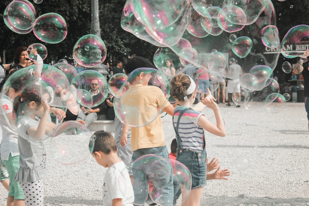 un gruppo di bambini che giocano con le bolle di sapone