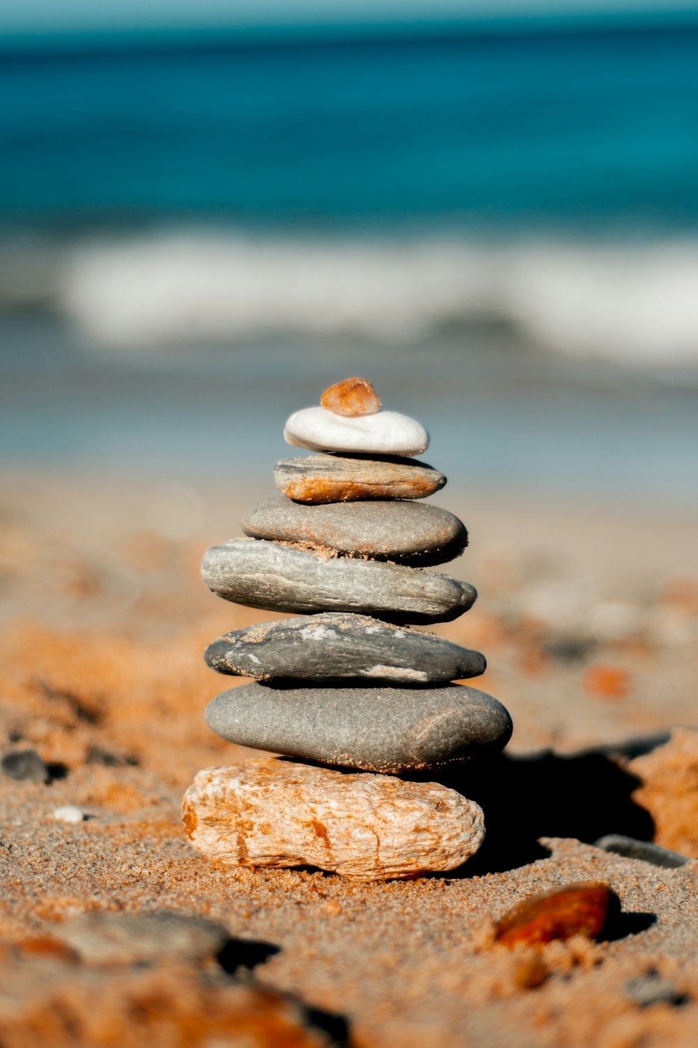 stack of gray stones on brown sand during daytime