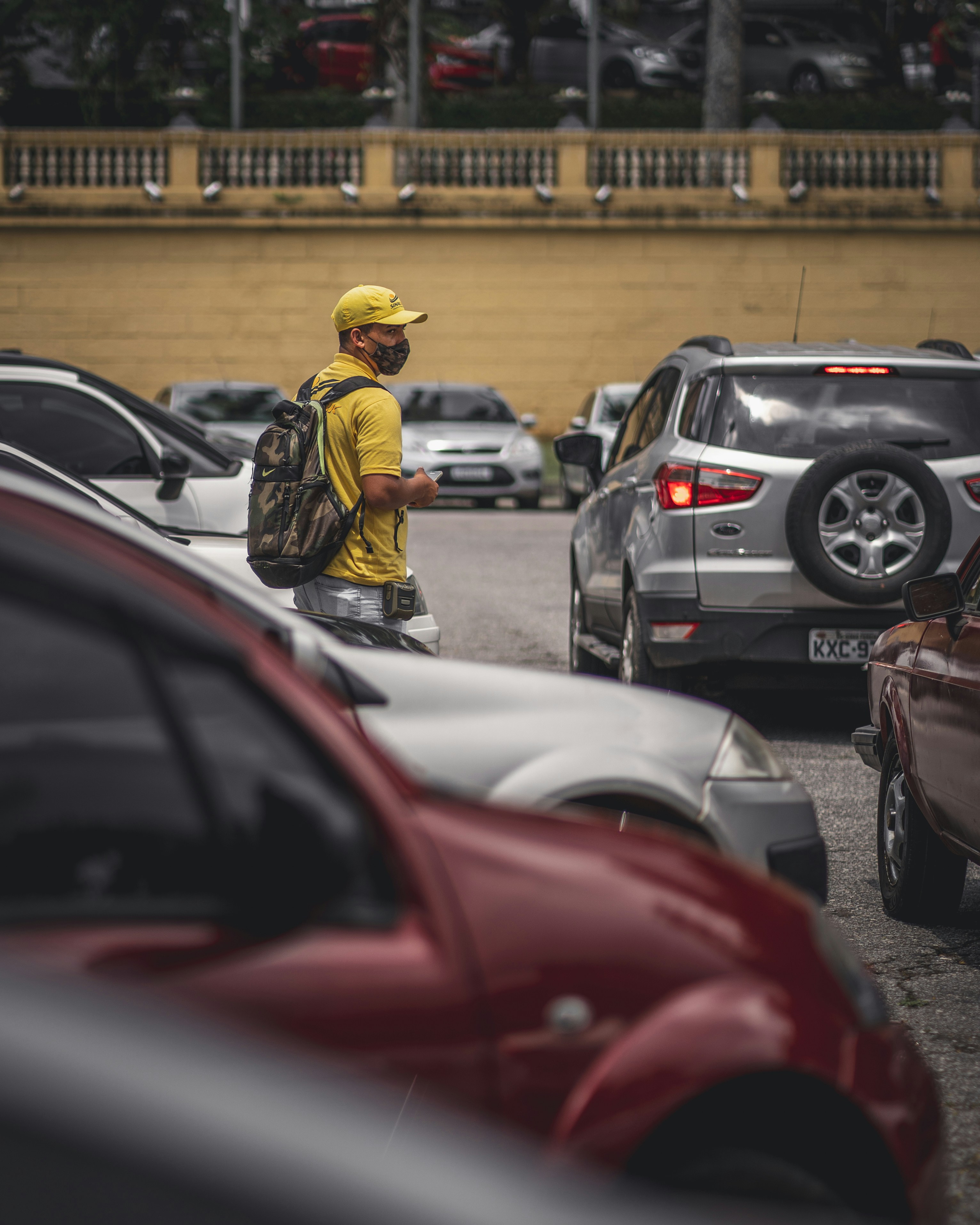 man in yellow hard hat standing beside black car during daytime
