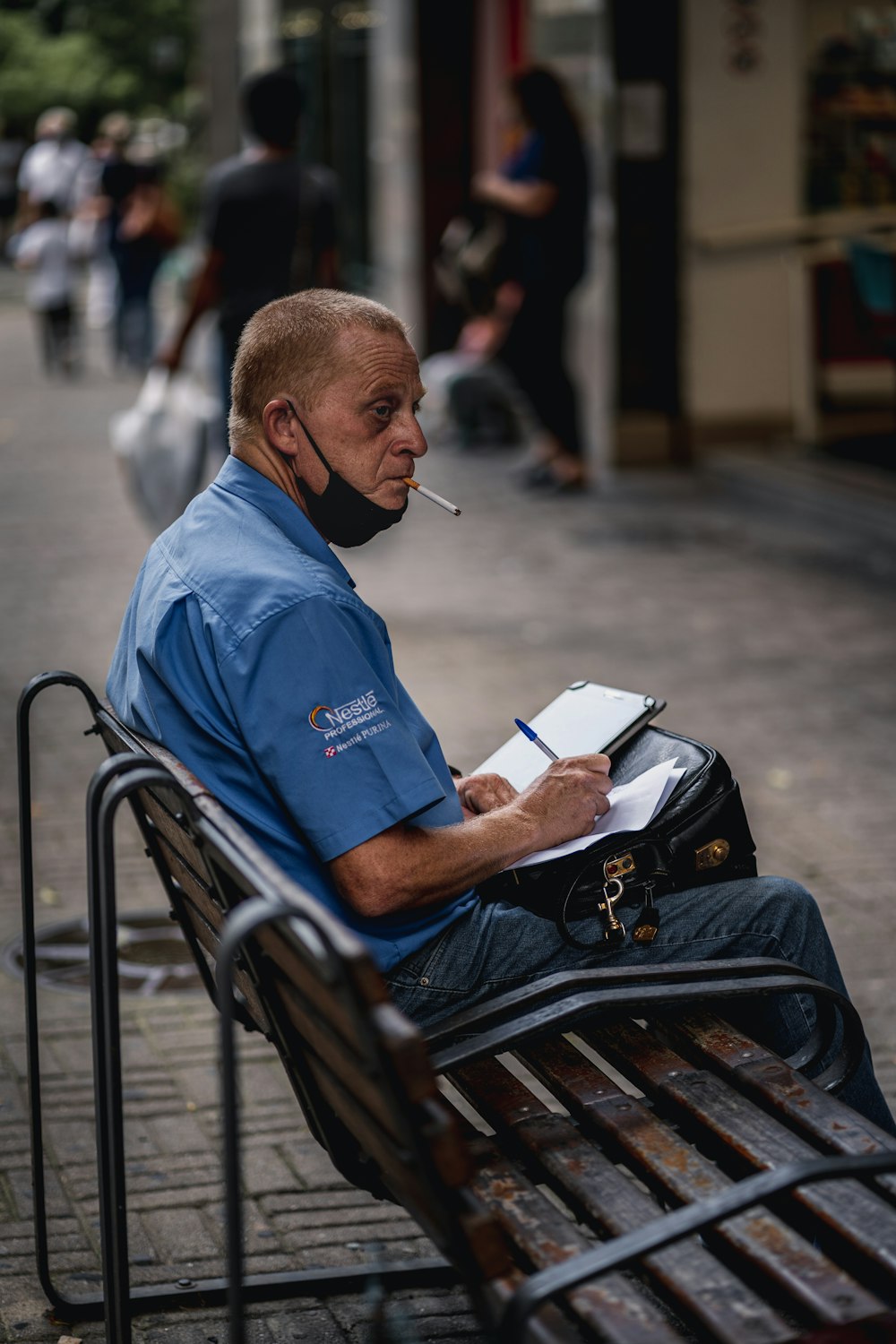man in blue polo shirt sitting on black steel chair reading book