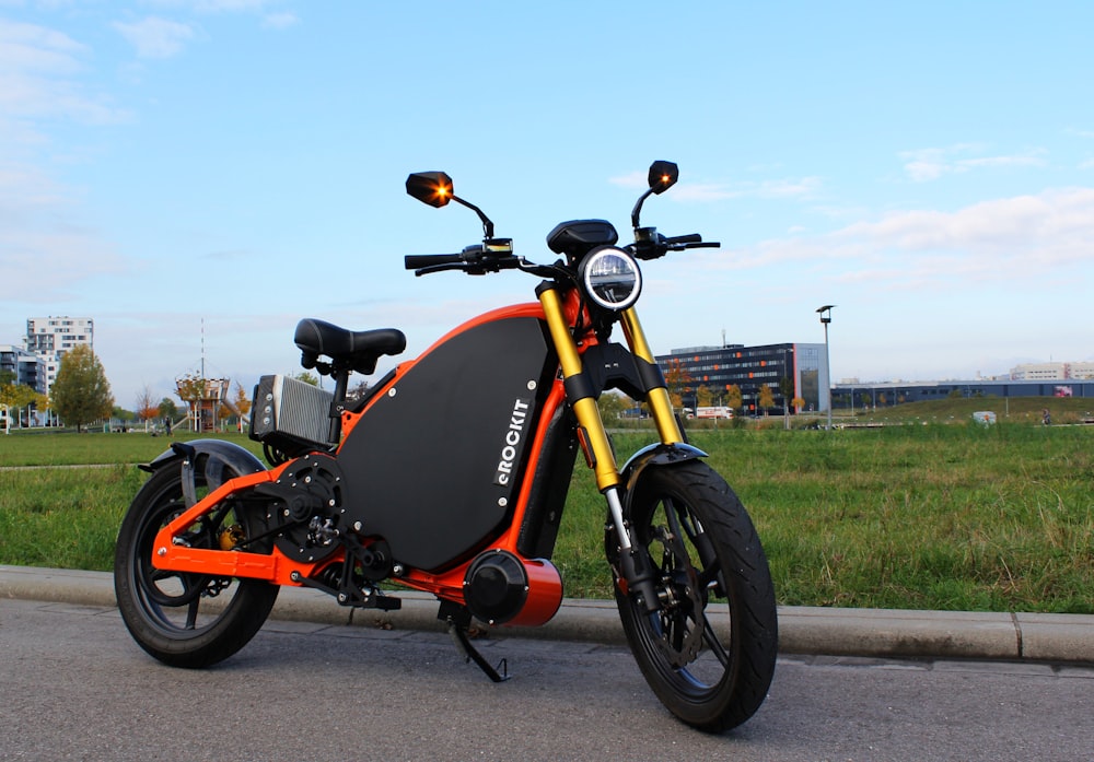 orangefarbenes und schwarzes Motorrad tagsüber unterwegs