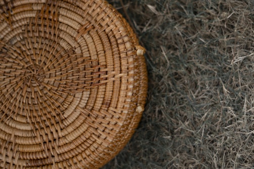 Handwoven cork and wicker basket displayed on a wooden table.
