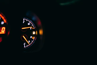 A modern car dashboard illuminated in soft yellow gold tones.