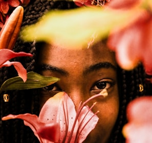 woman in black and yellow shirt with pink flower on her face