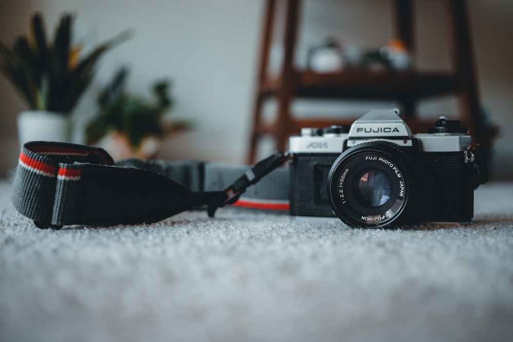 black and silver nikon dslr camera on gray textile