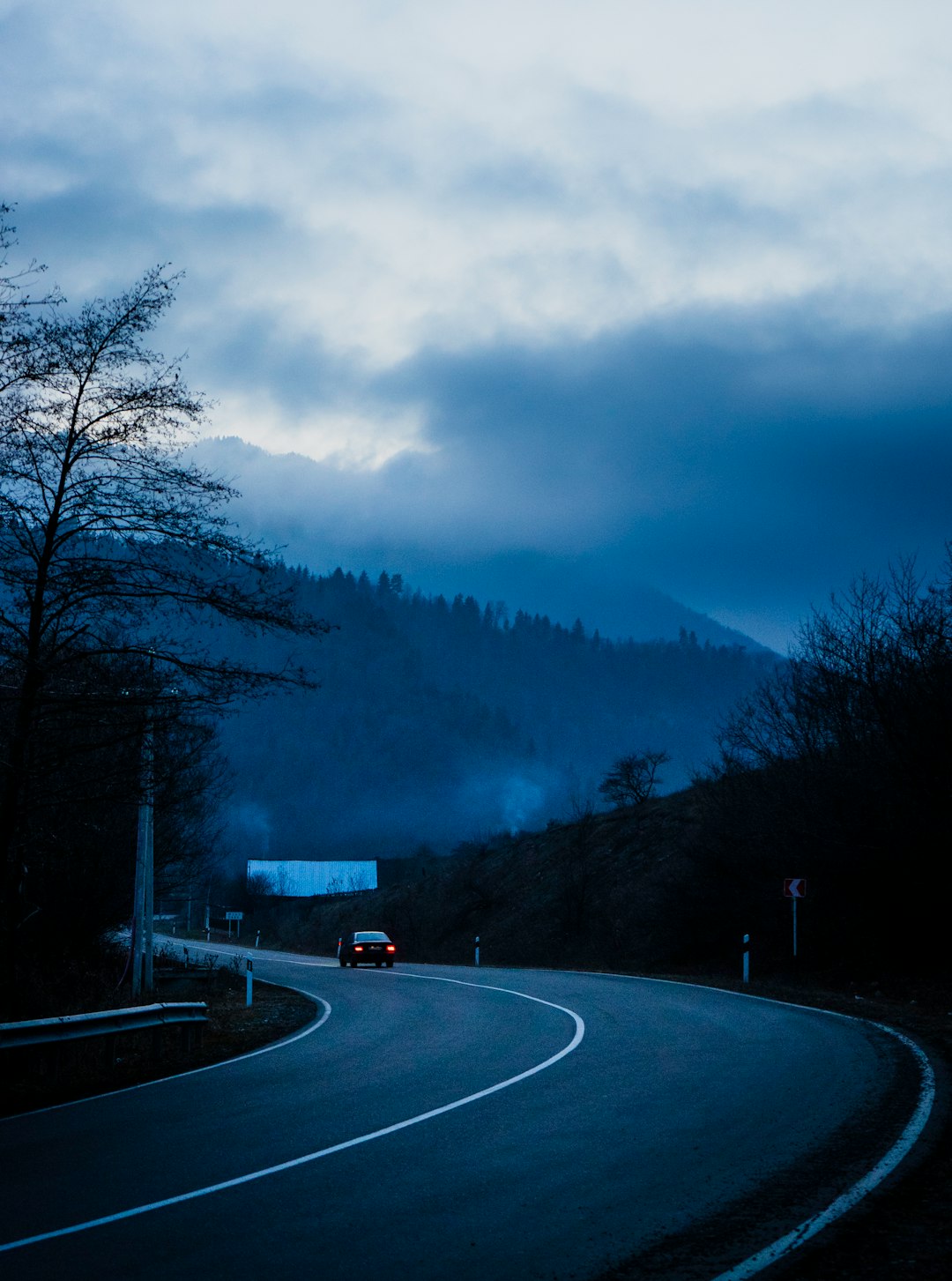 black car on road near trees during daytime