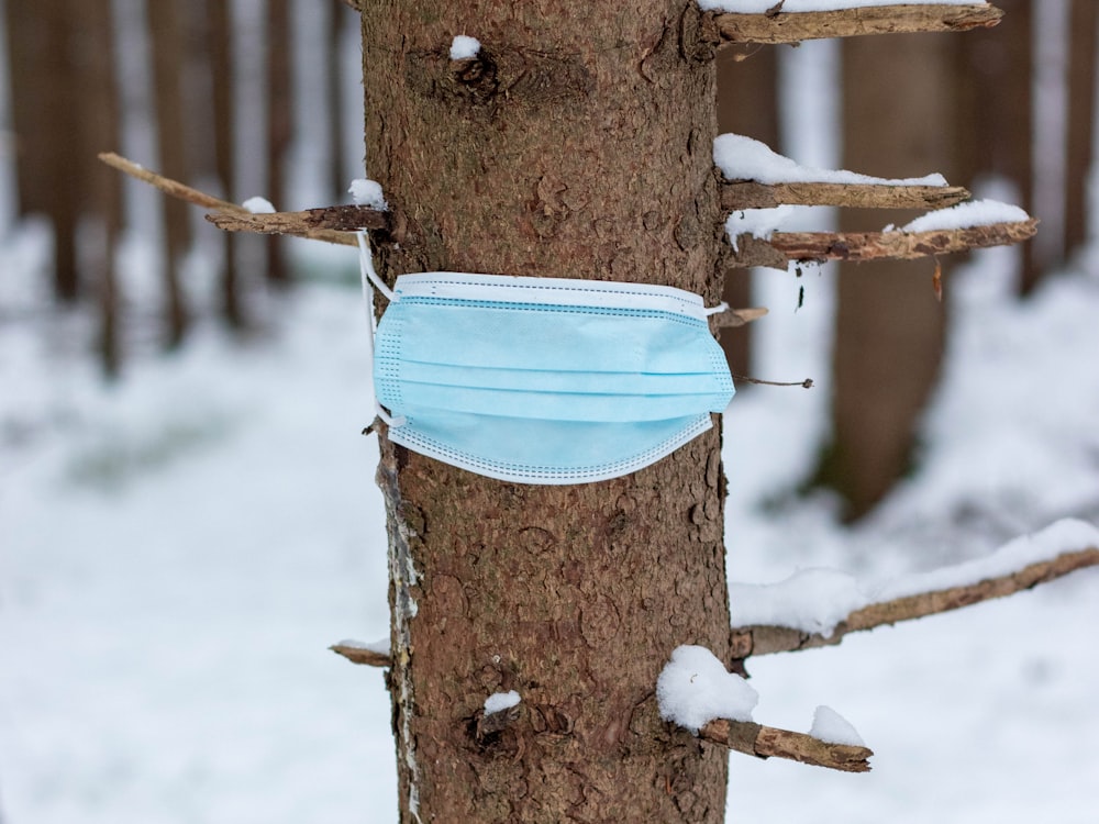 blue and white sling bag on brown wooden post