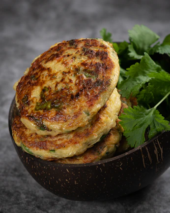 Close-up of crispy aloo tikki topped with tangy chutneys and fresh coriander.