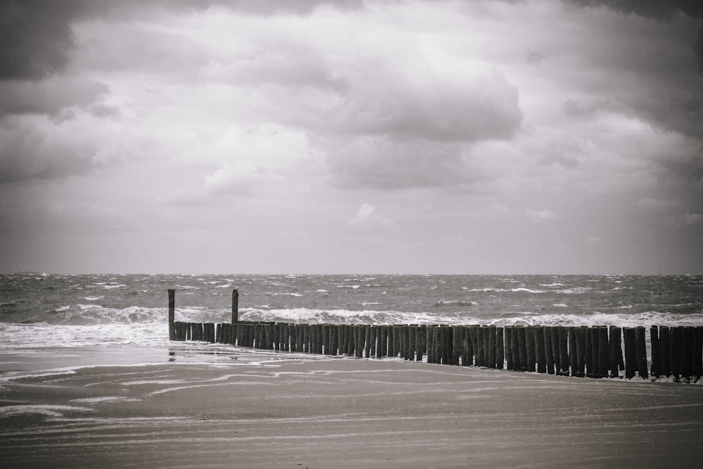 brown wooden dock on sea under white clouds during daytime