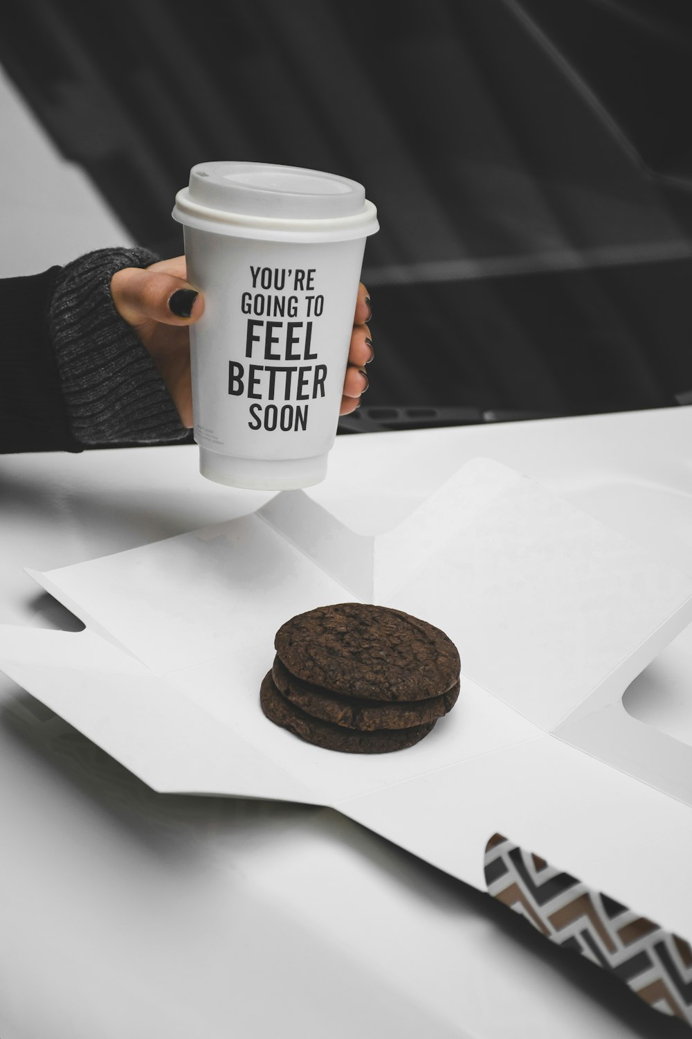 white and black coffee cup on white paper