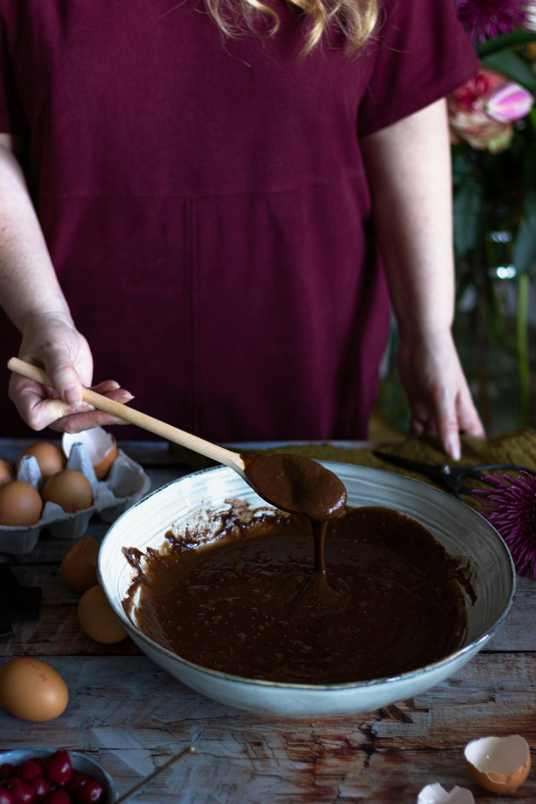 person in pink shirt holding brown wooden ladle