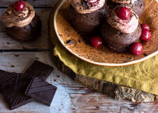 person holding brown wooden tray with red fruits