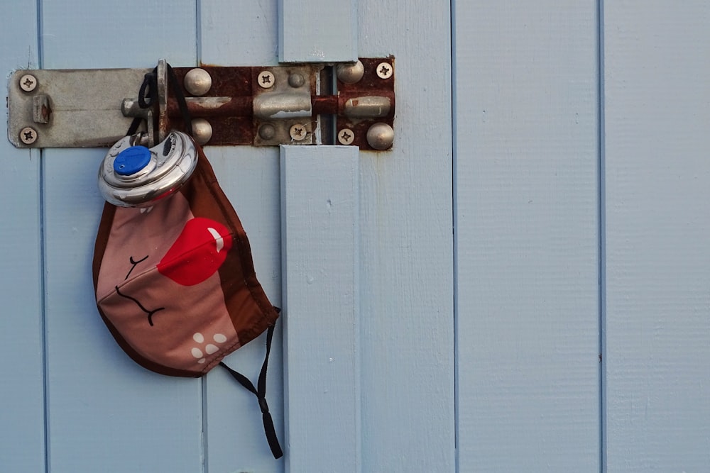 red and white fire extinguisher on white wooden door