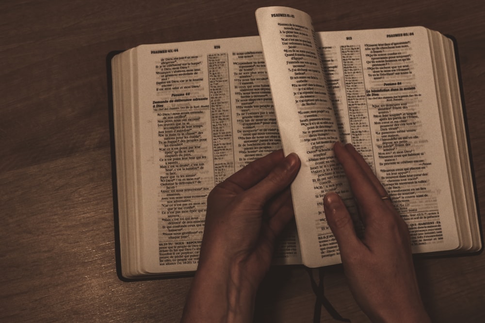 person holding white book page